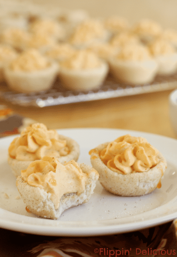 Gluten free snickerdoodle cookie cups are soft and chewy, with all the sweetness and spiciness of a traditional snickerdoodle cookie. Filled with creamy pumpkin mousse and drizzled with just a touch of sweet salted caramel sauce they taste like the pumpkin pie from your dreams.
