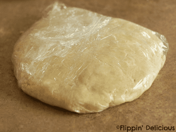 gluten free pastry dough disc wrapped in plastic wrap befing chilling