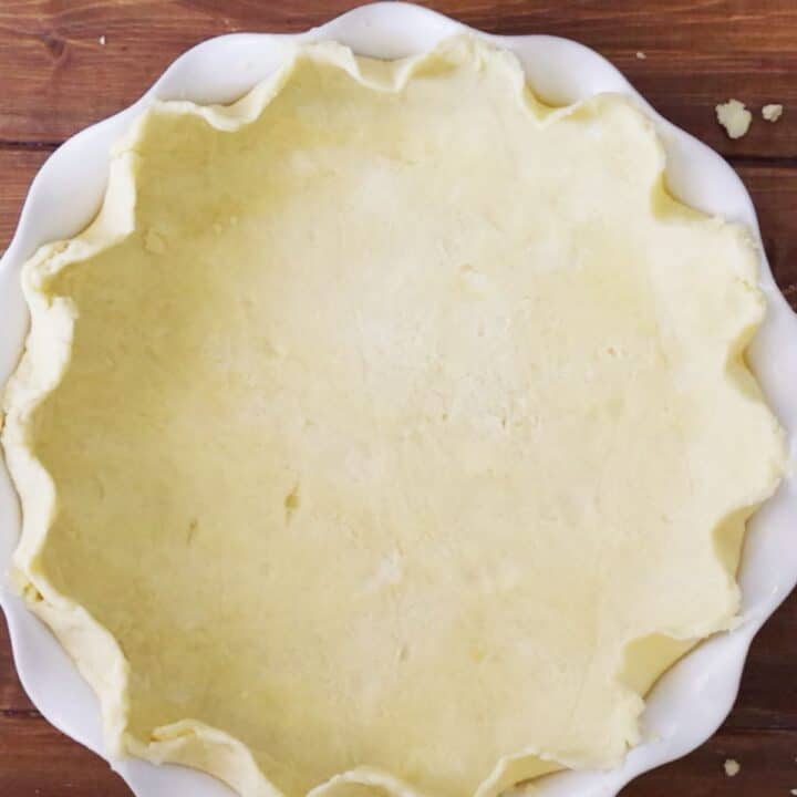 gluten free pie crust with crimped edges on a wooden table