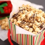 Christmas Caramel Popcorn with peanuts, coconut, and chocolate drizzled on top. Perfect for holiday gift giving!