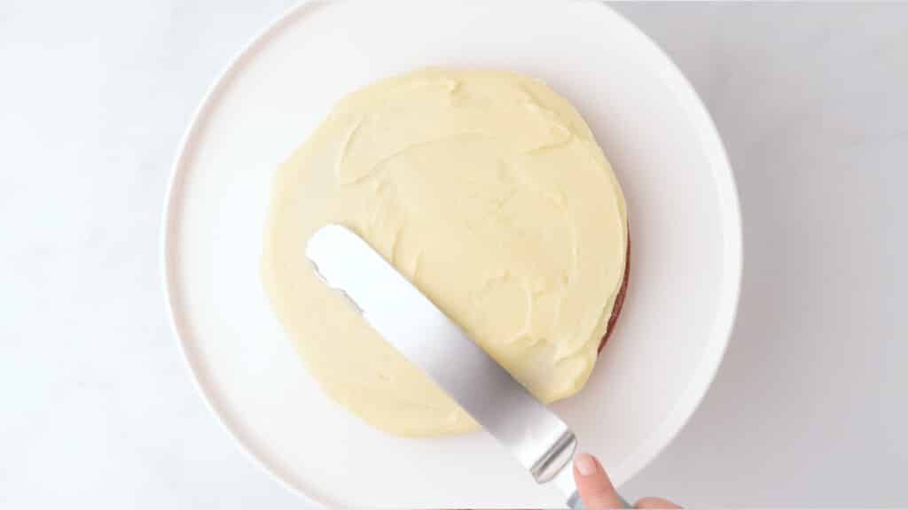 frosting gluten free red velvet cake with offset spatula