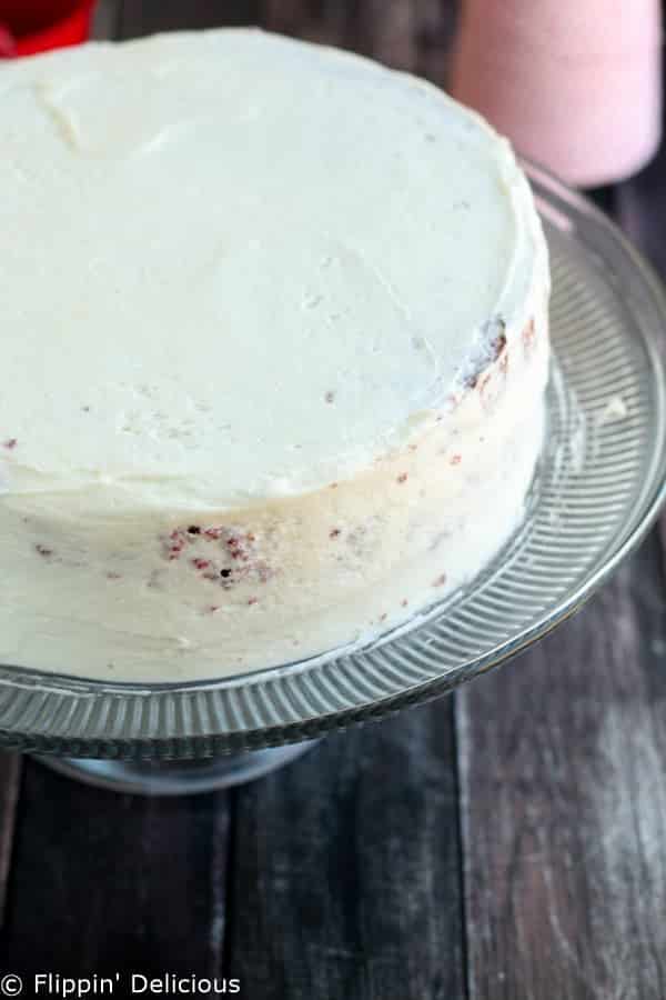 Step-by-step photos make stacking three layers of gluten free red velvet cake piped w/ fluffy rosettes a 