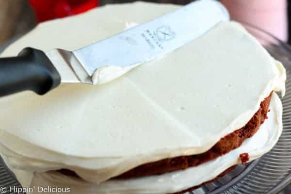 Step-by-step photos make stacking three layers of gluten free red velvet cake piped w/ fluffy rosettes a 