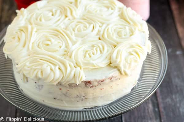 Step-by-step photos make stacking three layers of gluten free red velvet cake piped w/ fluffy rosettes a 