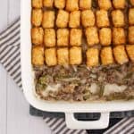 overhead gluten free tater tot casserole made with gluten free cream of mushroom soup in a white casserole dish with ground turkey