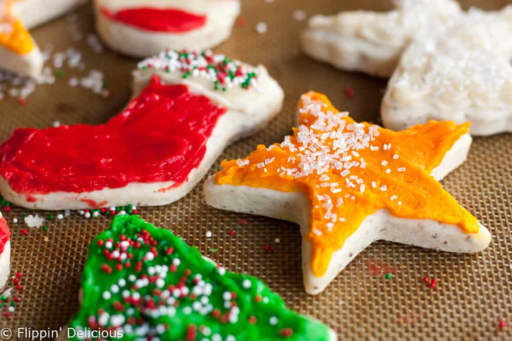 Christmas holiday frosted gluten free vegan sugar cookies in the shape of a tree, stocking, star, and candy cane