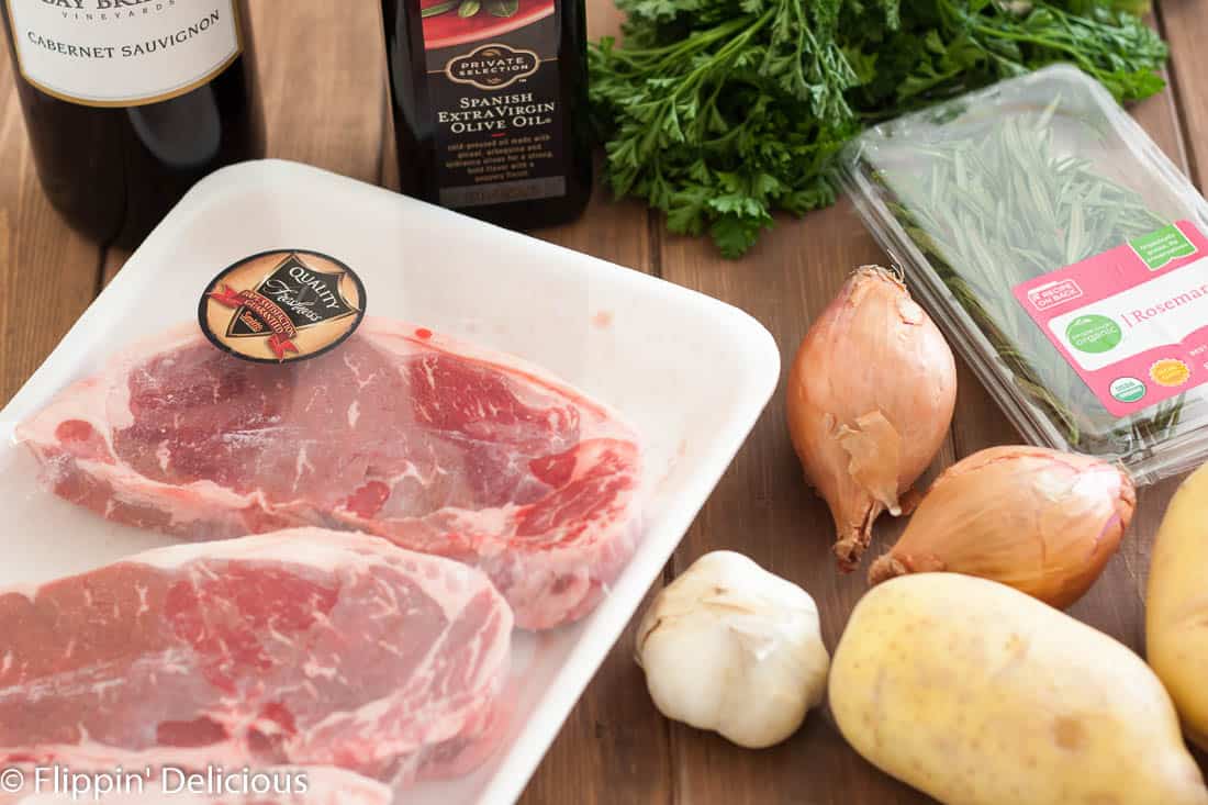 Juicy new york strip steaks marinated in red wine, rosemary, garlic and shallots with garlic and herb baked fries make a perfect at home date!