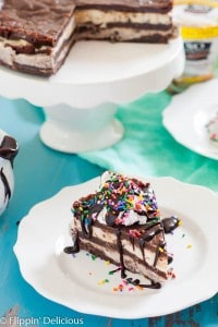 This Vegan Brownie Ice Cream Cake makes the most epic celebration cake ever! Gluten free Vegan Brownies layered with gluten free dairy free cookies and cream and cookie dough ice creams, topped with coconut whipped cream, hot fudge sauce, and SPRINKLES!