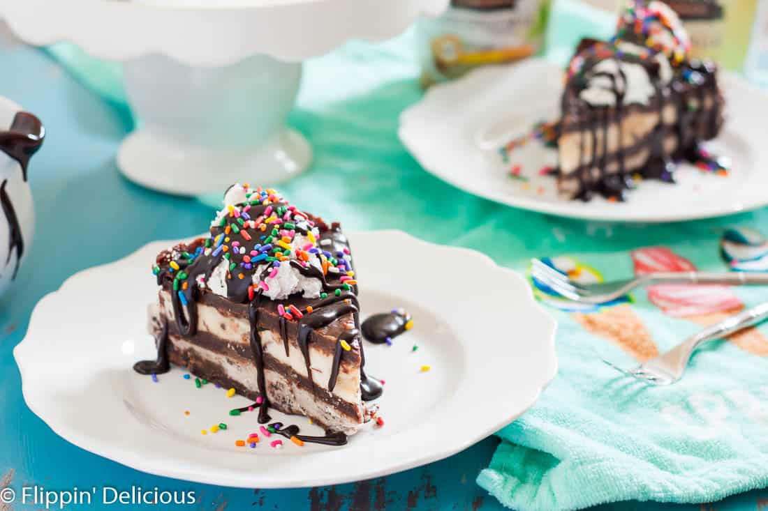 This Vegan Brownie Ice Cream Cake makes the most epic celebration cake ever! Gluten free Vegan Brownies layered with gluten free dairy free cookies and cream and cookie dough ice creams, topped with coconut whipped cream, hot fudge sauce, and SPRINKLES!