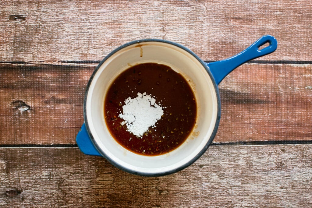 blue enamel saucepan with gluten free teriyaki marinade and cornstarch on a wooden table