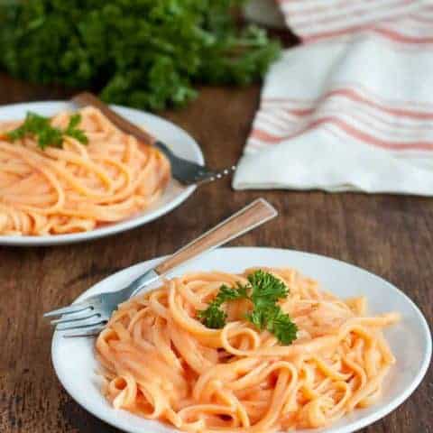 Vegan Roasted Red Pepper Alfredo, gluten-free and dairy-free, is an easy weeknight meal that the entire family can enjoy. With minimal prep, the sauce is ready before the pasta is finished cooking!