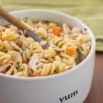 Instant Pot gluten free chicken noodle soup in white bowl with wood handle spoon