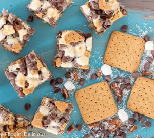 overhead view of vegan gluten free magic cookie bars with marshallows, pecans, coconut, graham crackers, and chocolate chips