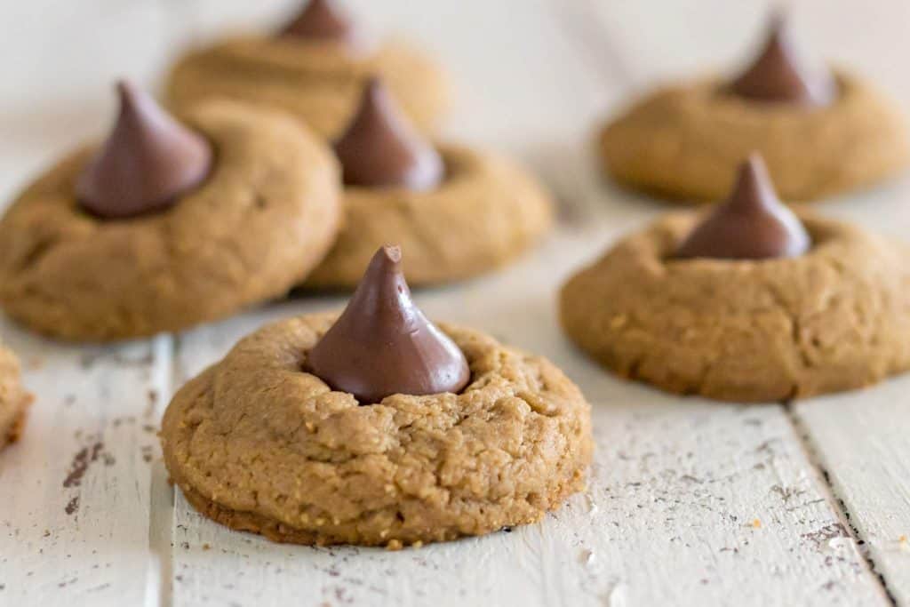 Gluten free blossom cookies made with sunflower seed butter cookies with hershey's kiss on a white farmhouse table 