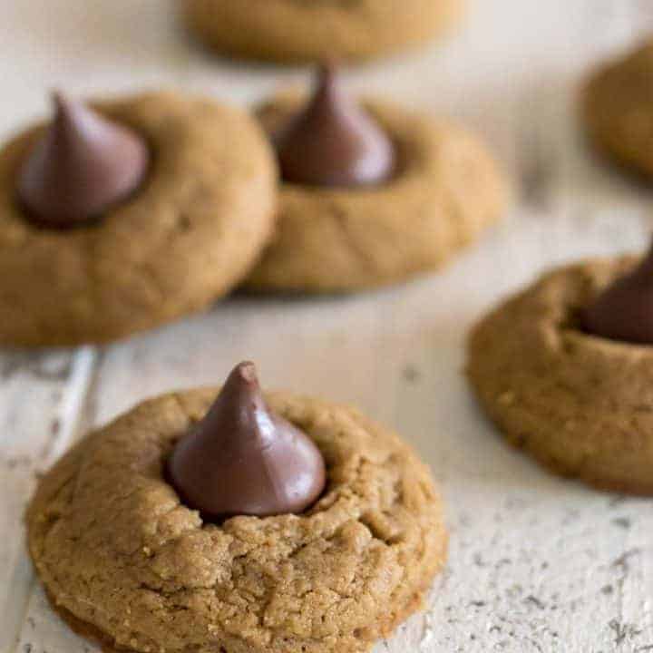 Gluten free blossom cookies made with sunflower seed butter cookies with hershey's kiss on a white farmhouse table