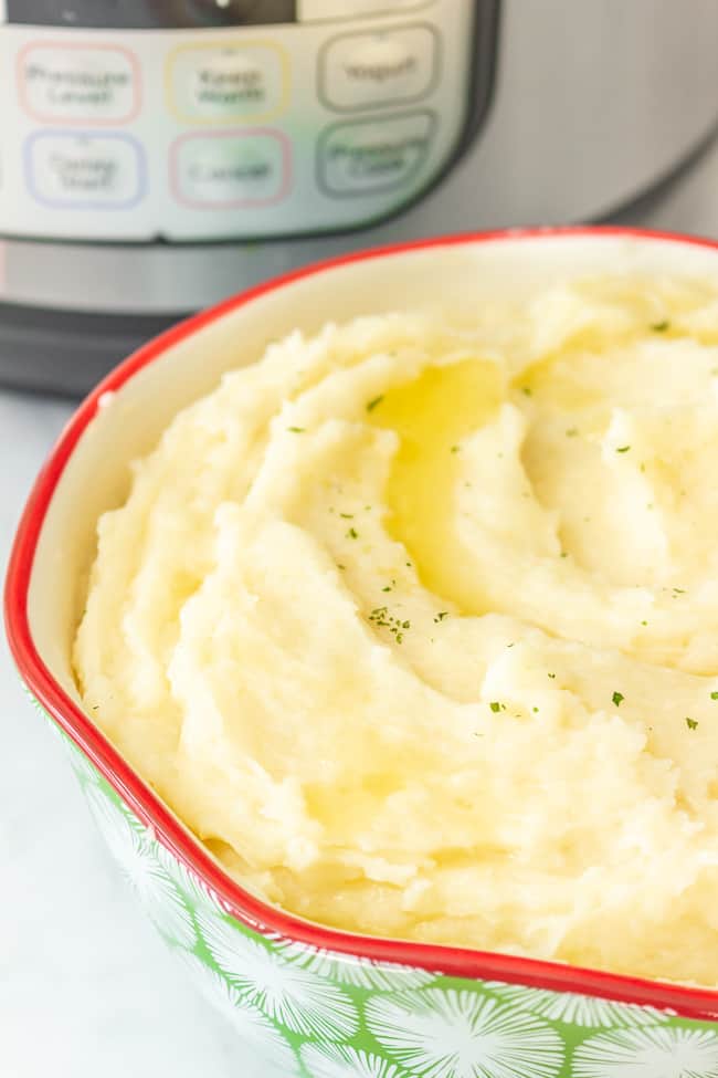 dairy free mashed potatoes made in an Instant Pot in a serving dish with a swirl of melted dairy free butter