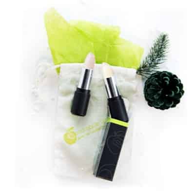rallye balm and exfoliate stick on canvas bag with green tissue paper and a pinecone