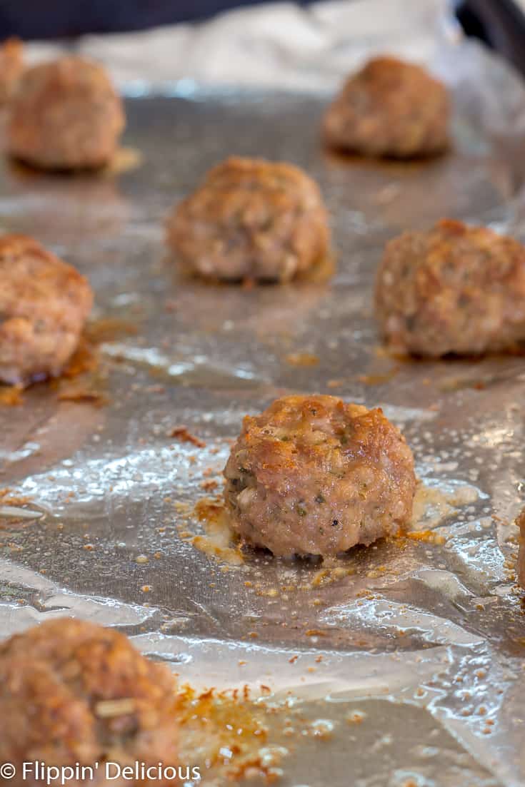 gluten free turkey meatballs sitting on aluminum foil and baking sheet