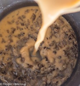 adding milk and broth to gluten free cream of mushroom soup in saucepan