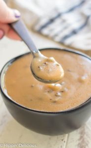 bowl of gluten free cream of mushroom soup with a spoon scooping out a bite