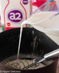 pouring milk into saucepan to make gluten free pudding