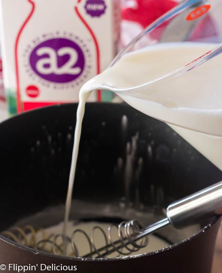 pouring milk into saucepan to make gluten free pudding 