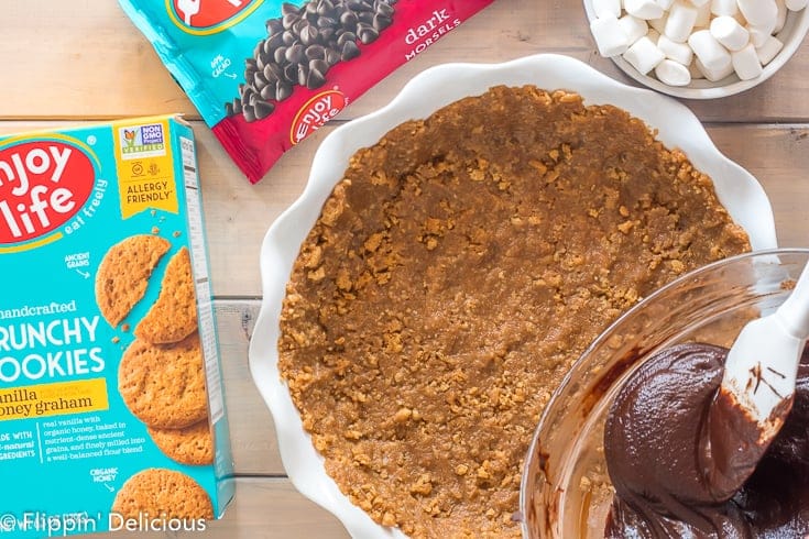 pouring vegan fudge filling into gluten free graham cracker crust 