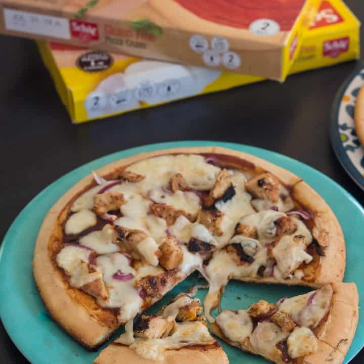 gluten free grilled barbecue chicken pizza on a blue plate with two slices cut out