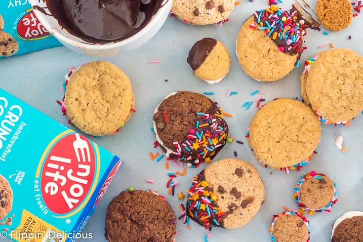 overhead view of gluten free sandwich cookies dipped in chocolate and decorated with rainbow sprinkles