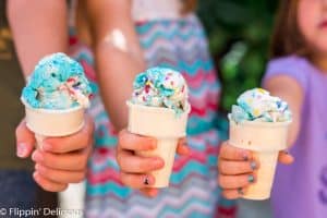 three girls holding gluten free ice cream cones, each with a scoop of no churn vegan cake batter ice cream