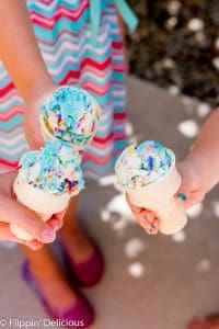 overhead of three girls holding gluten free ice cream cones, each with a scoop of no churn vegan cake batter ice cream with sprinkles