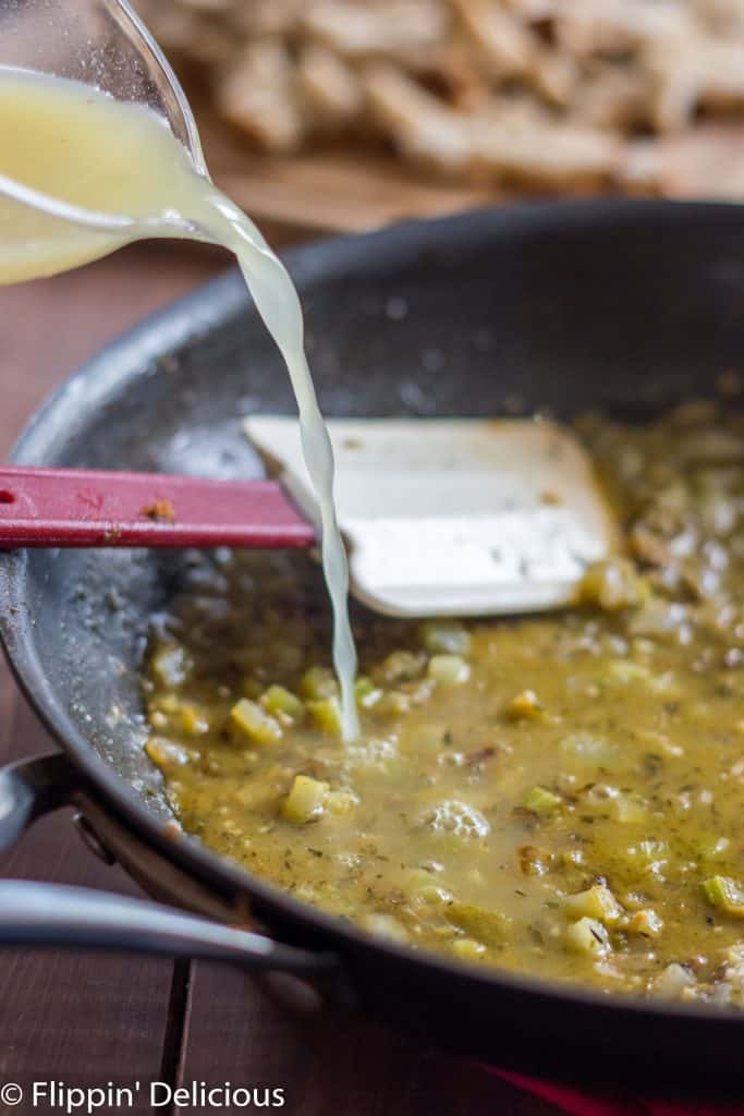 adding broth to sauteed veggies and herbs to deglaze skillet