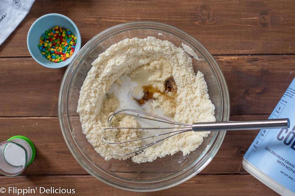 adding liquid ingredients (coconut milk, coconut oil, and vanilla extract) for low carb protein bites to dry ingredients