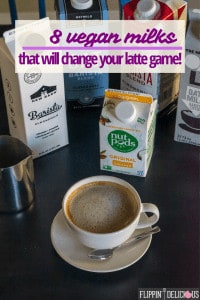 text "8 vegan milks that will change your latte game" over picture of dairy free latte in small latte mug with a stainless steel pitcher and cartons of dairy free barista milk in the background including NutPods, The New Barn, Califia Farms,and Oatly