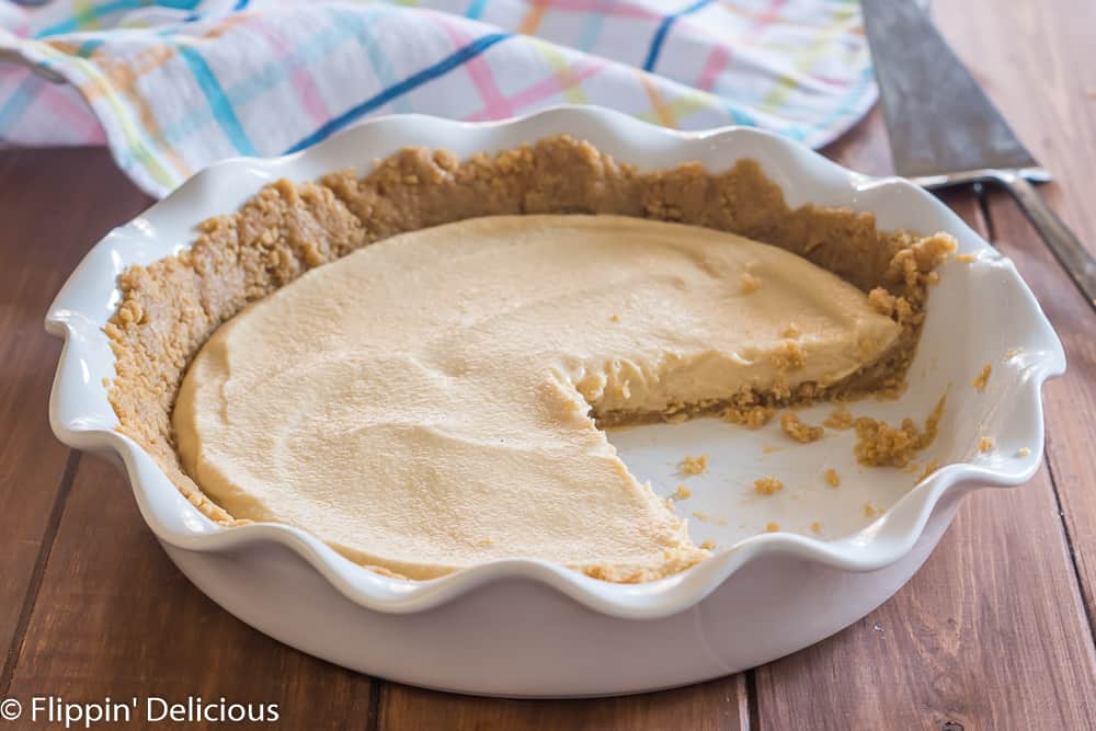 vegan pudding pie in a white pie plate, with several slices removed