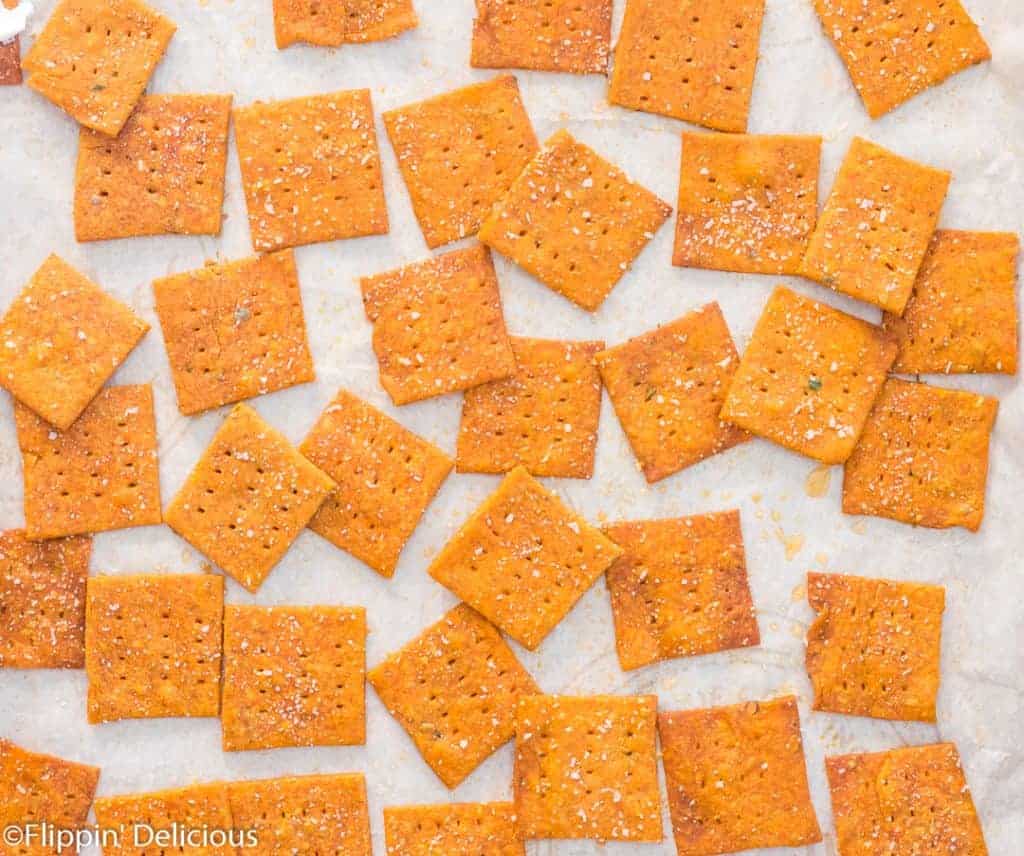 overhead view of gluten free pizza crackers on a baking sheet lined with parchment paper