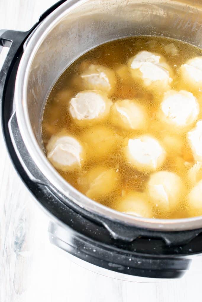 gluten free dumplings floating in chicken soup in an instant pot pressure cooker