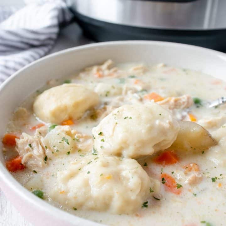 white bowl with gluten free chicken and dumplings soup with an instant pot in the background