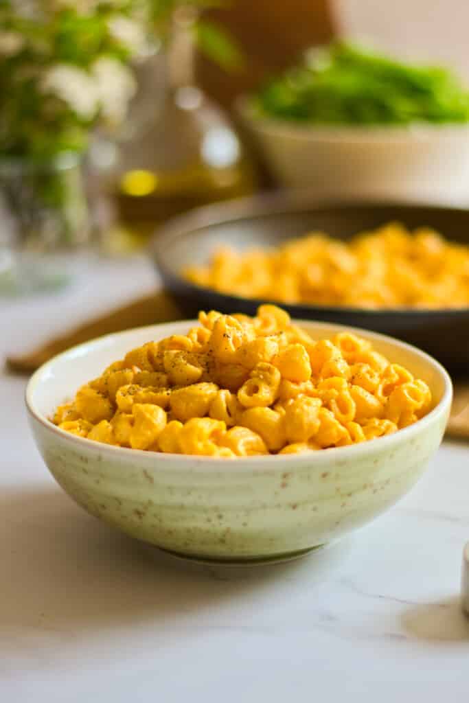 two bowls with vegan mac and cheese on a white table