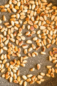 Close up photo of toasted pine nuts in a pan