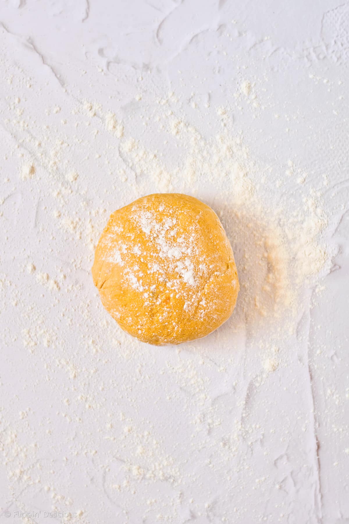 pumpkin gluten free gnochi dough on a white floured marble table