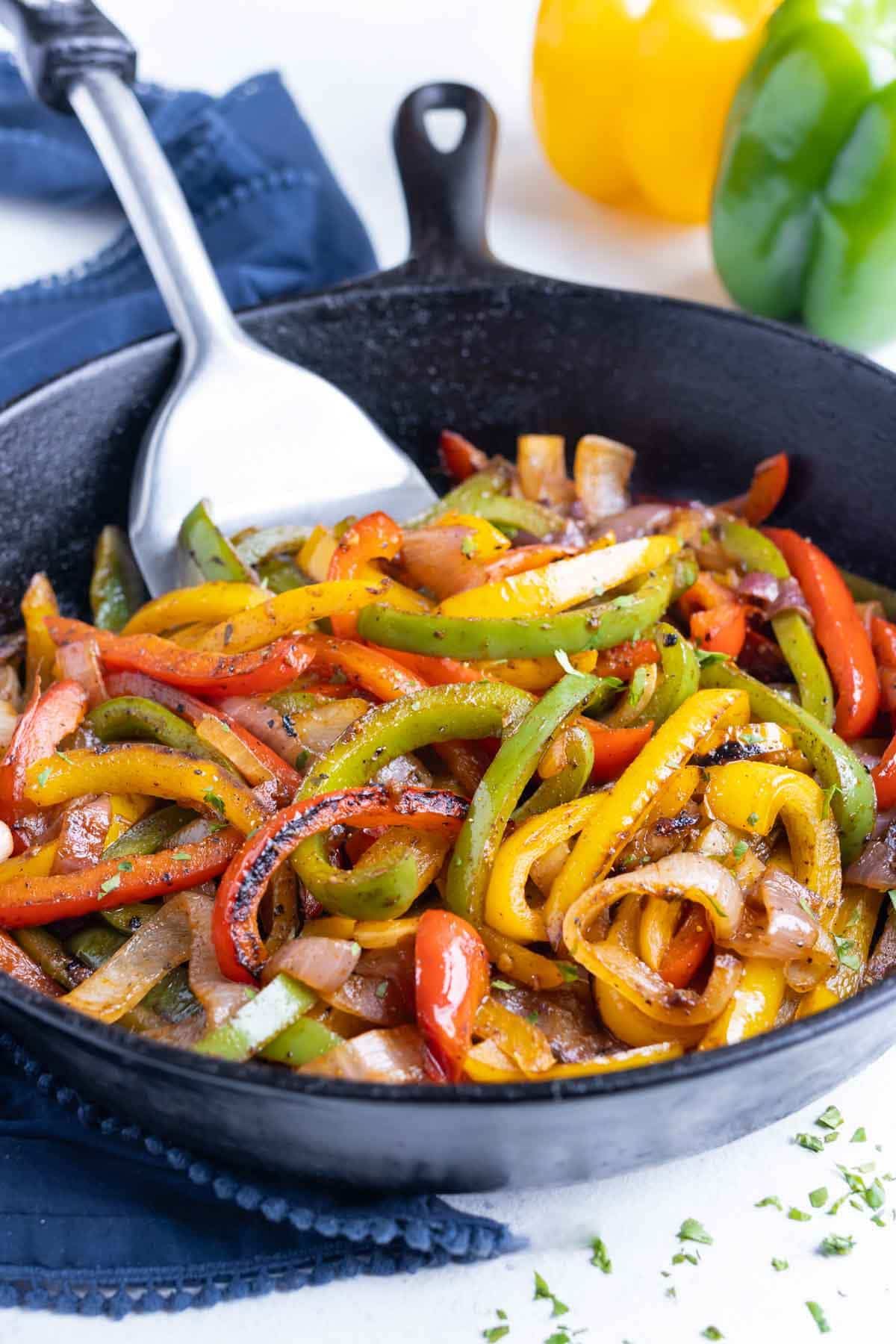 15-Minute Fajita Vegetables in a black skillet with a spatula.