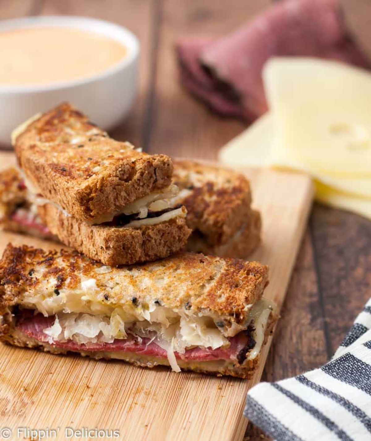Gluten-Free Reuben Sandwich Dippers With Thousand Island Dressing on a wooden cutting board.