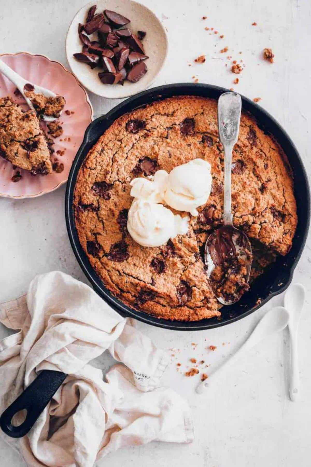 Cookie Cake in a black skillet with a spoon.