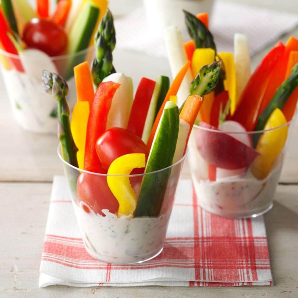 Dill Vegetable Dip in glass cups with sliced veggies.