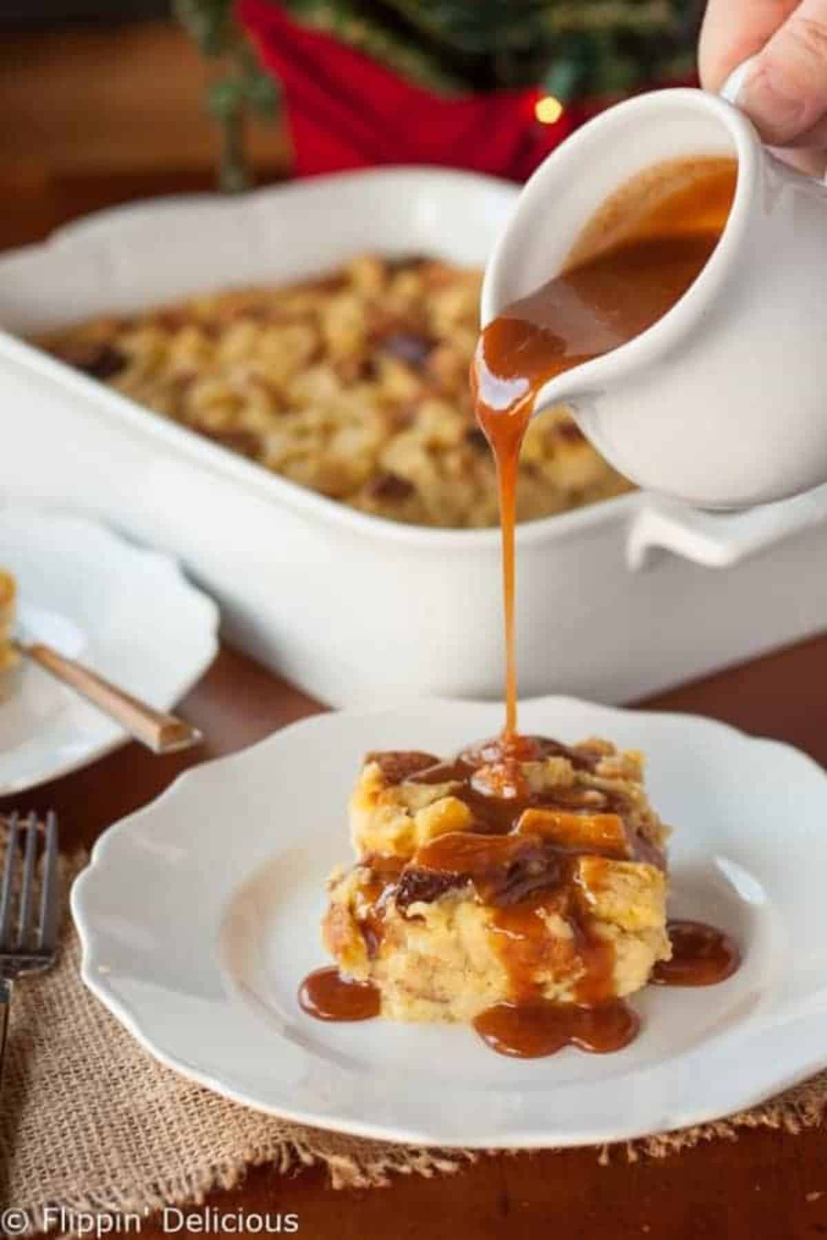 Gluten-free Eggnog Bread Pudding with Bourbon Caramel Sauce on a white plate.