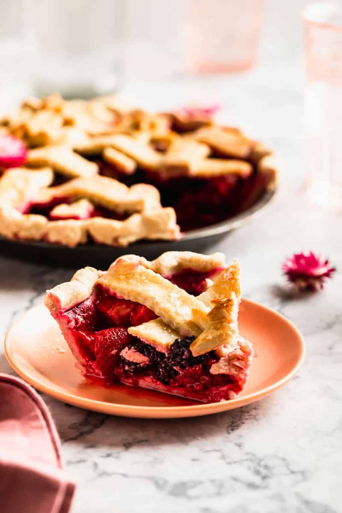 A piece of Gluten-Free Triple Berry Pie on an orange plate.