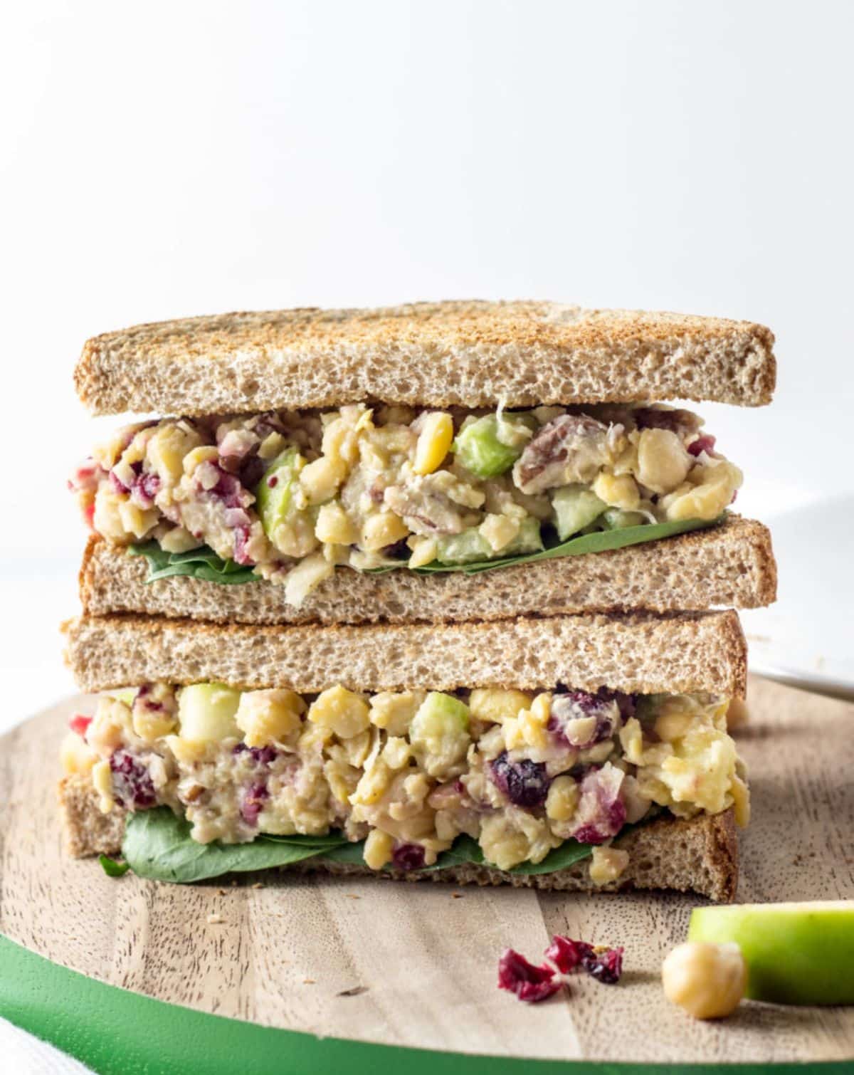 Cranberry Apple Chickpea Salad Sandwich on a wooden cutting board.