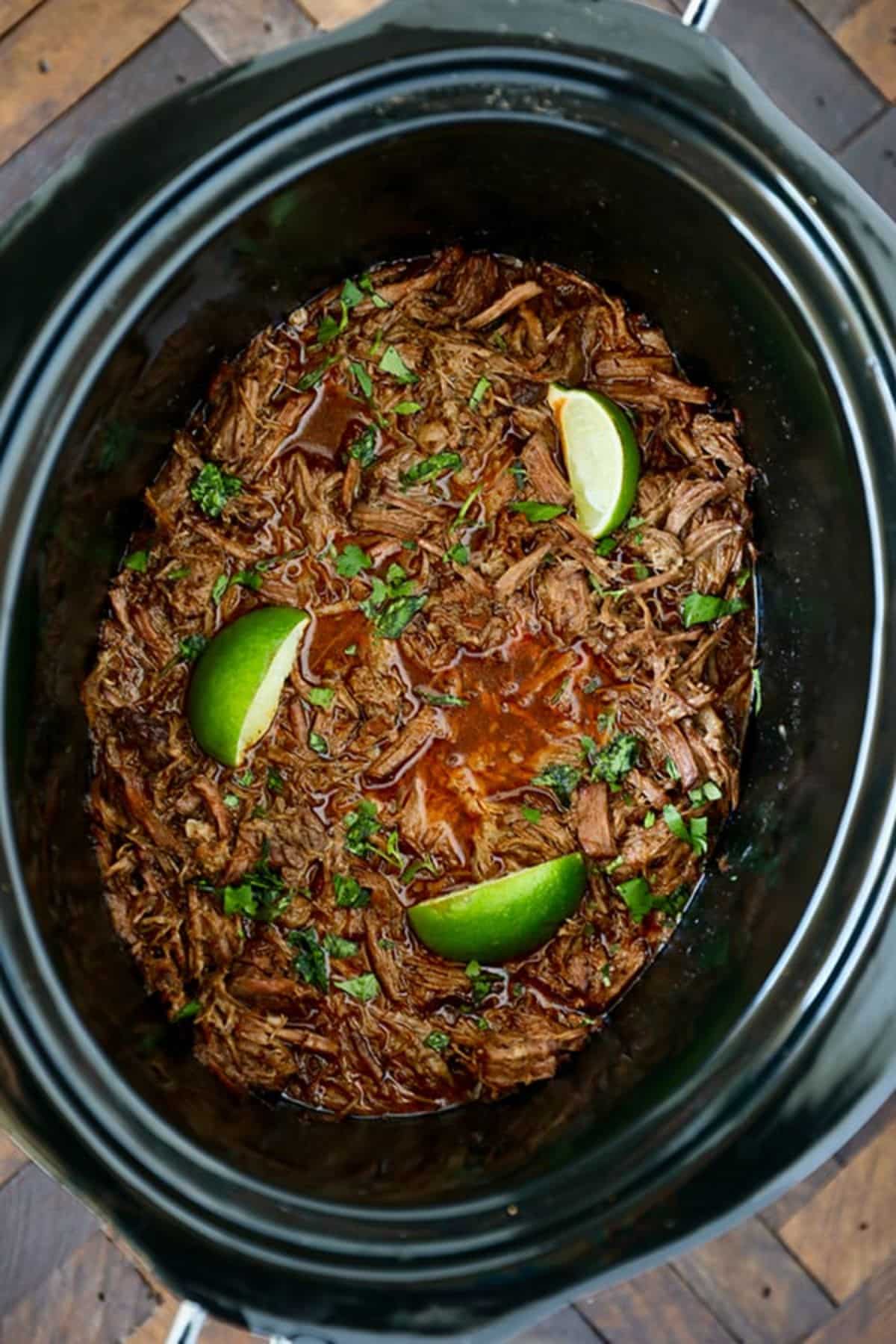 Slow Cooker Barbacoa with slices of lime.