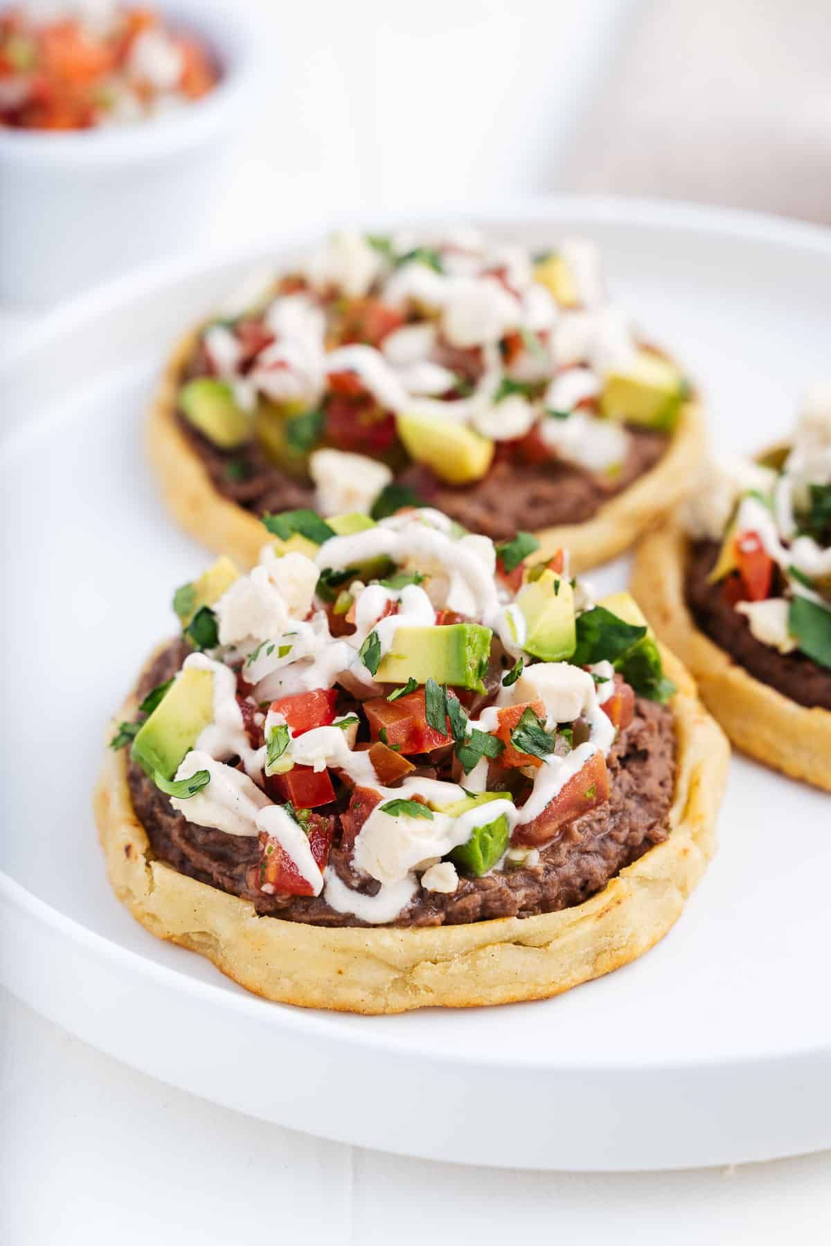 Mexican sopes on a white tray.